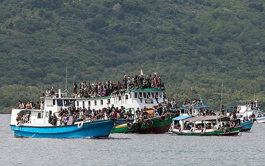 Zwaar beladen boten nemen bij het Indonesische eiland Flores deel aan een processie voor Goede Vrijdag. beeld EPA