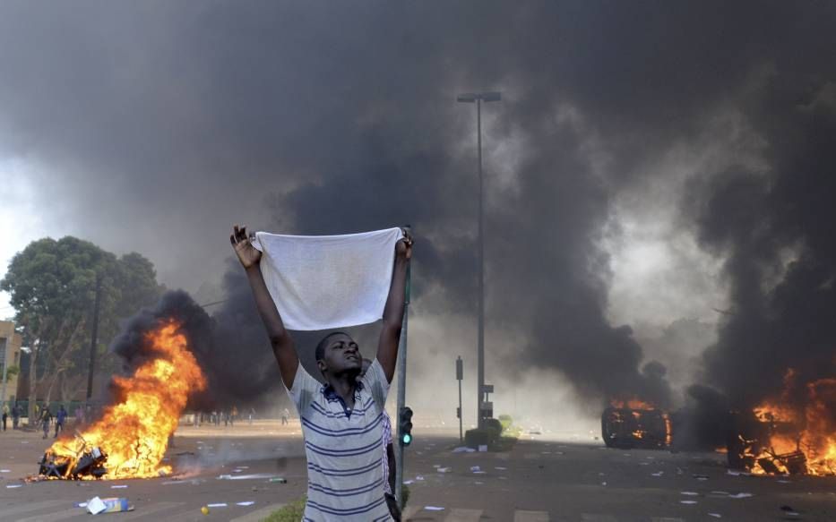 OUAGADOUGOU. Een demonstrant, gisteren buiten het parlementsgebouw in de Burkinese hoofdstad Ouagadougou. Honderden boze Burkinezen bestormden gisteren het parlement en staken auto’s en documenten in de brand. Ze eisen het vertrek van president Blaise Com