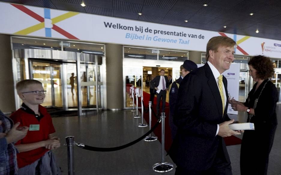 Koning Willem-Alexander verlaat, met de Bijbel in de hand, de bijeenkomst waar de Bijbel in Gewone Taal werd gepresenteerd. beeld ANP