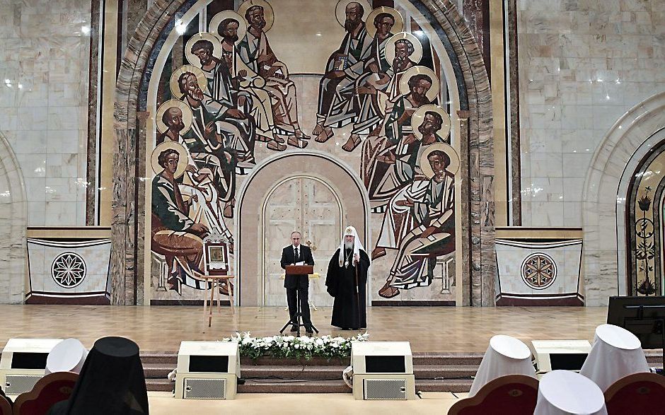 De Russische president Poetin (l.) sprak vrijdag de raad van bisschoppen van de Russisch-Orthodoxe Kerk toe. Rechts de leider van de kerk, patriarch Kirill.   beeld AFP, Alexey Nikolsky