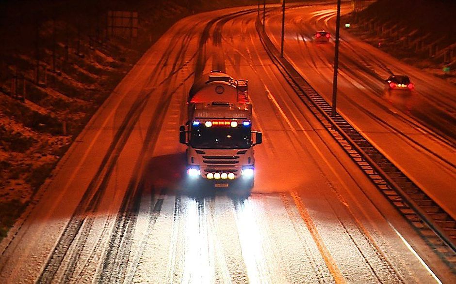 Een vrachtwagen rijdt in de nacht van eerste op tweede kerstdag door de sneeuw over de ring van Groningen. De sneeuw die viel in Groningen bleef liggen, omdat de temperatuur beneden het vriespunt was. beeld ANP