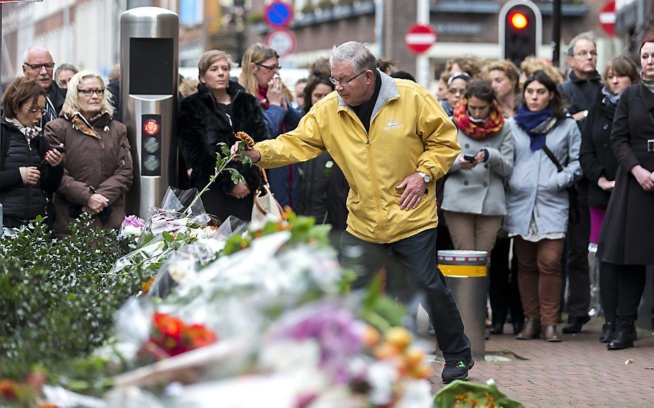 Mensen leggen bloemen bij de ambassade van Frankrijk in Den Haag. beeld ANP