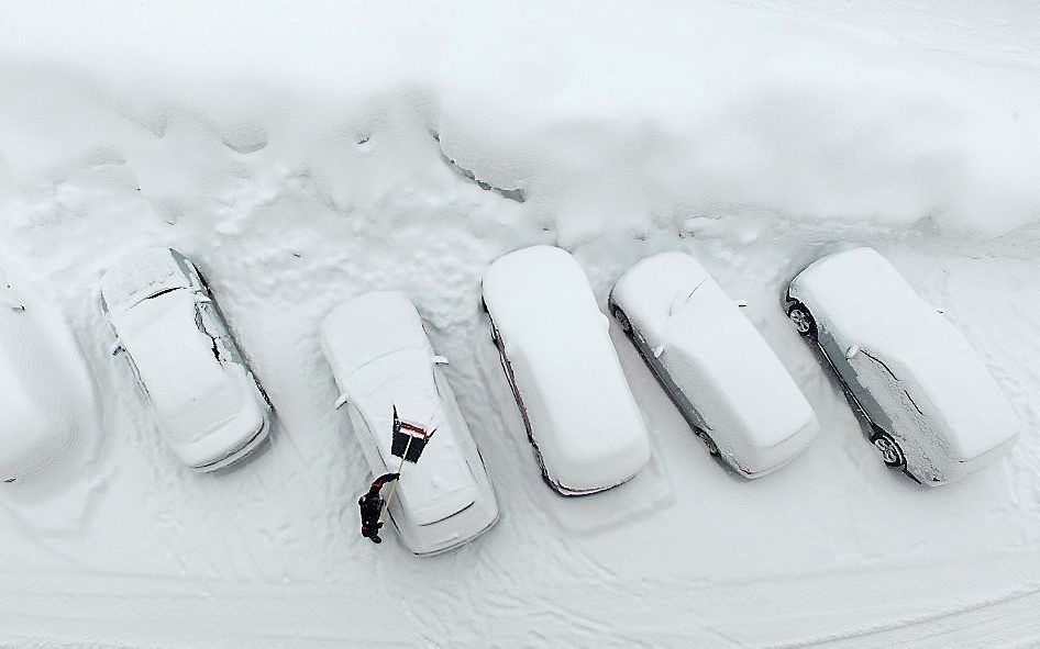 Ondergesneeuwde auto's in het Oostenrijkste dorp Ramsau am Dachstein. beeld AFP