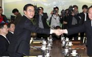 De Zuid-Koreaanse minister van Hereniging, Cho Myung Gyun (l.), schudde dinsdag in de grensplaats Panmunjom de hand van de Noord-Koreaanse onderhandelaar Ri Son Gwon. De twee kwamen overeen dat Noord-Korea mag meedoen aan de winterspelen in Zuid-Korea, vo