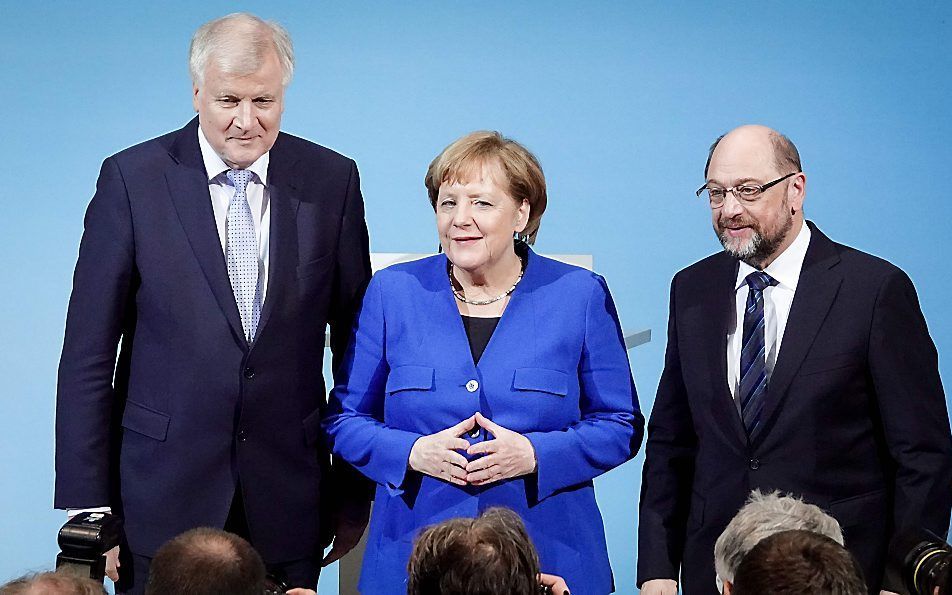 SPD-leider Schulz (r.) staat onder druk van partijleden om in onderhandelingen met Merkel (m.) en CSU-leider Seehofer (l.) meer te bereiken. beeld AFP, Kay Nietfeld