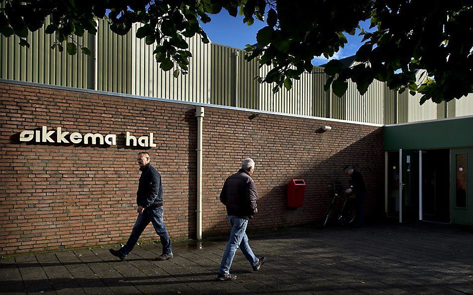 Friese mannen lopen de Sikkemahal in Zwaagwesteinde in en uit voor het DNA-onderzoek.  Foto ANP