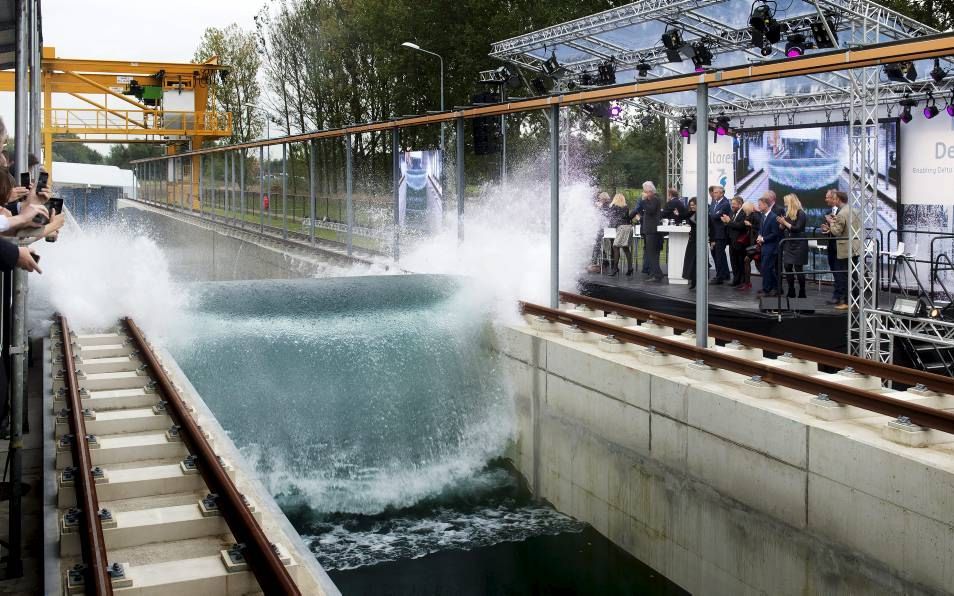 Met een „mooie, feestelijke golf” is gisteren in Delft de Deltagoot geopend. Minister Kamp en minister Schultz van Haegen haalden bij die gelegenheid een nat pak. Experimenten in de 300 meter lange bak moeten zorgen voor betere en goedkopere dijken. Beeld