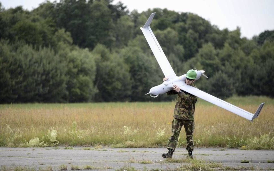 DEELEN. Defensie maakt sinds woensdag gebruik van een nieuwe, digitale ”drone”. Een militair sjouwt het toestel na de landing op z’n schouders weg. Beeld ANP