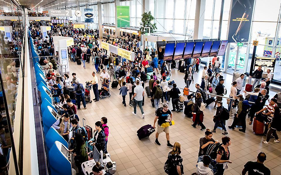 „Een vaak gehoord argument is dat reizen per trein zo duur is. Maar je zou ook kunnen zeggen dat het reizen per vliegtuig veel te goedkoop is.” Foto: Vakantiedrukte op Schiphol, juli 2017. beeld ANP, Bart Maat