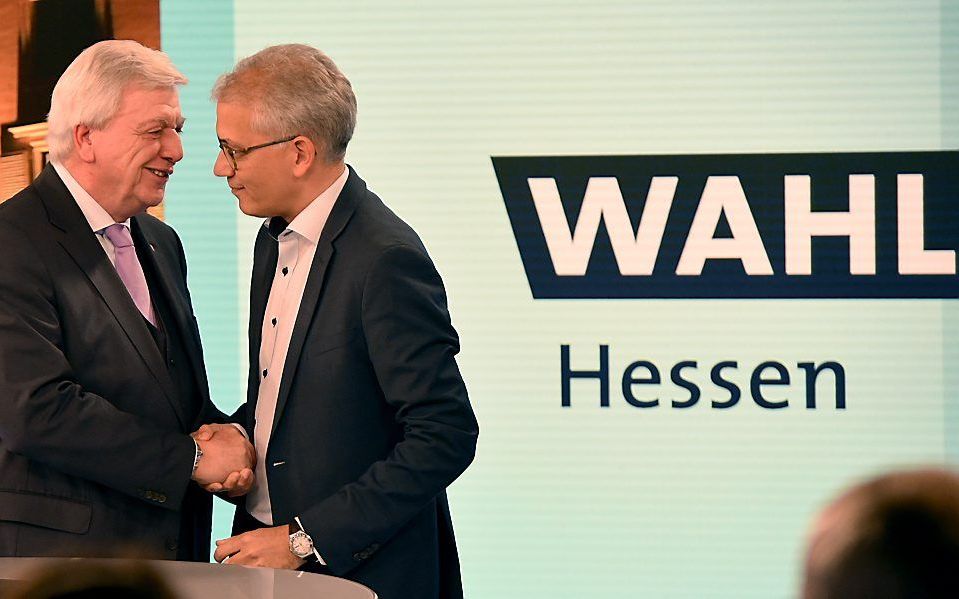 Volker Bouffier (l.) van de CDU schudt de hand van Tarek Al-Wazir (r.) van de Groenen. beeld EPA