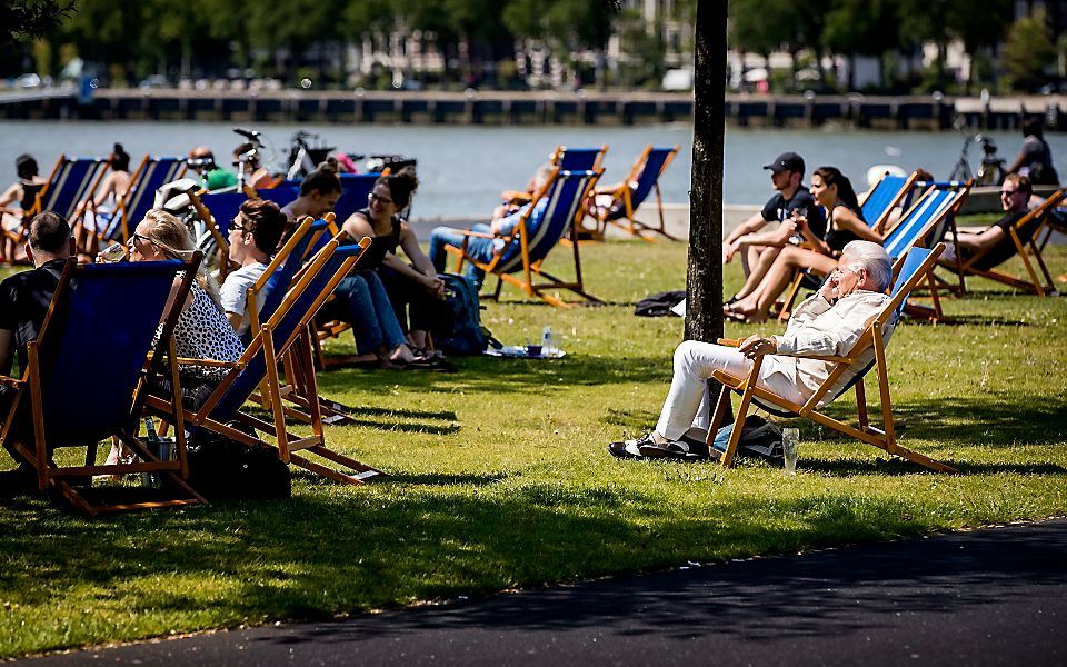 Mensen genieten van het mooie weer op de Kop van Zuid in Rotterdam. beeld ANP