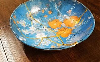 Blauwe schaal met bloemenmotief. De barsten zijn geheeld met goudverbinding.