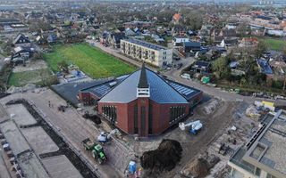 Modern kerkgebouw, met een toren; op de achtergrond woingen van IJsselmuiden en Kampen.