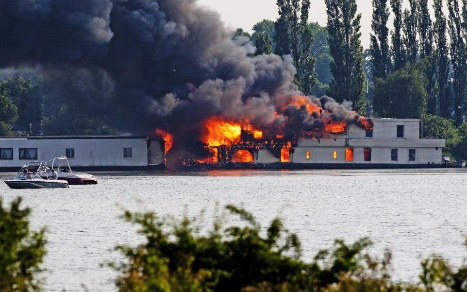 Aan de Diemerzeedijk aan het IJ in Amsterdam woedt dinsdag een brand op een woonboot. Foto ANP