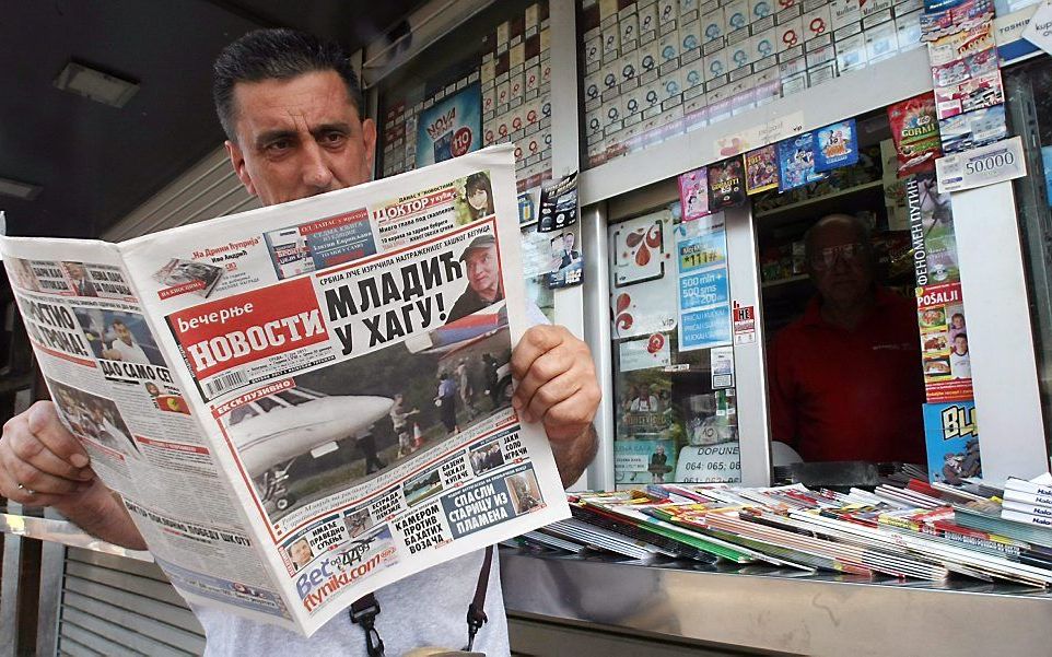 Een man leest nieuws over Mladic in Belgrado. Foto EPA