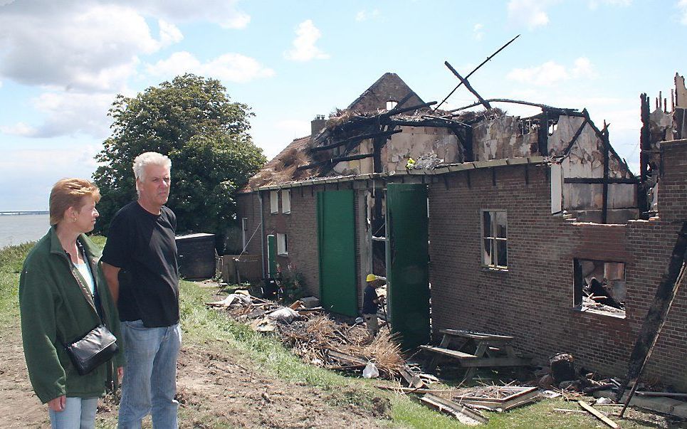 Maya Penning en Hans Oosterhof bij hun verwoeste hotel-restaurant. Een felle brand legde vorige week Herberg Tiengemeten grotendeels in de as. Ze zijn vastbesloten hun levenswerk weer op te bouwen. „Hoe dan ook, we gaan door, dit is ons leven en onze stek