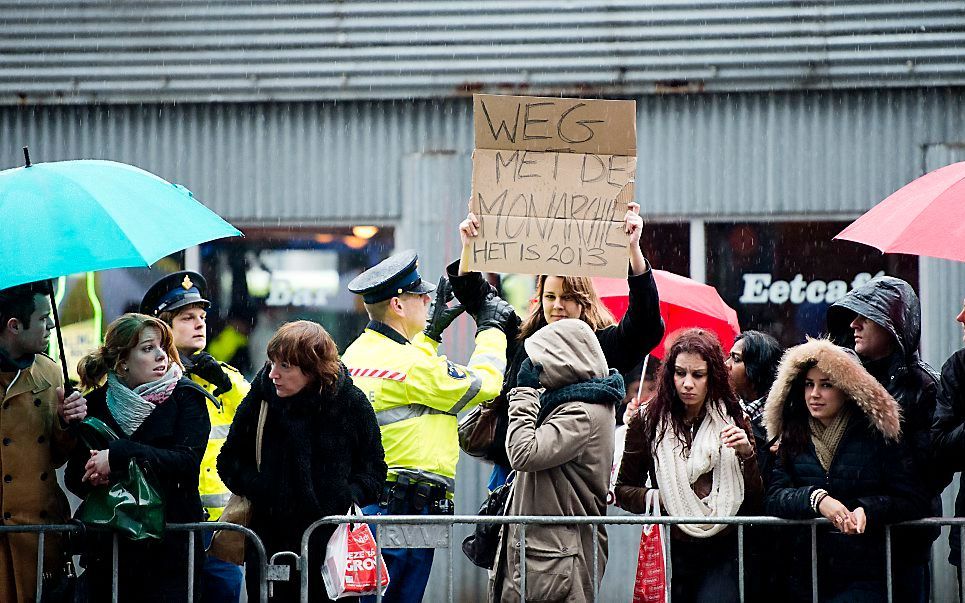 De demonstrante met het bord 'Weg met de monarchie, het is 2013'. Foto ANP