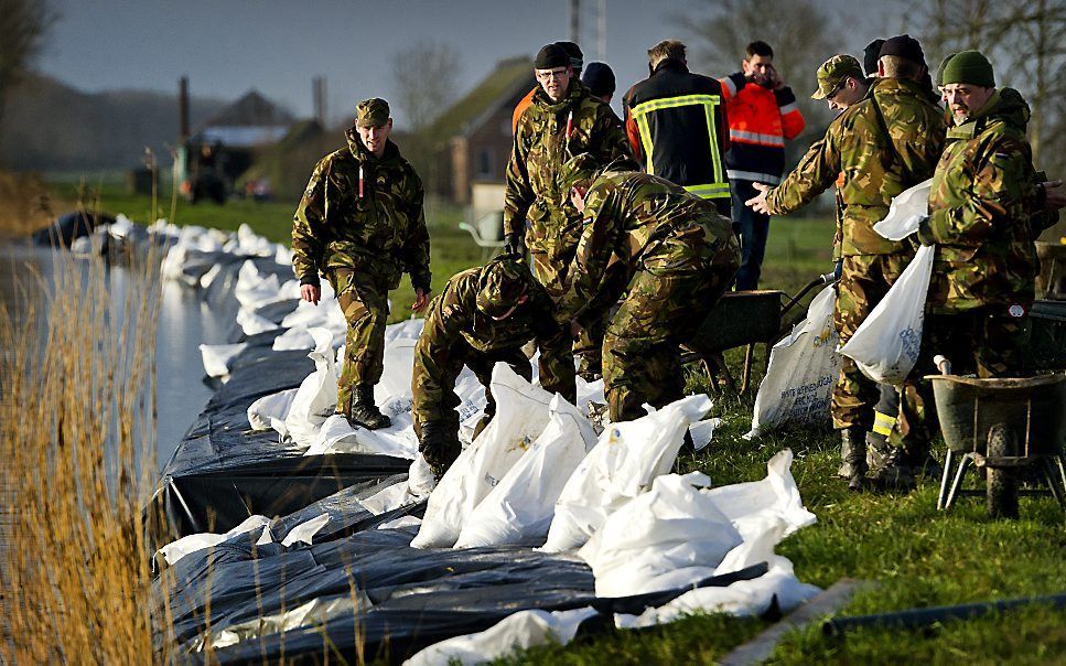 Militairen plaatsen zandzakken op de dijk van het Eemskanaal bij Woltersum. Foto ANP