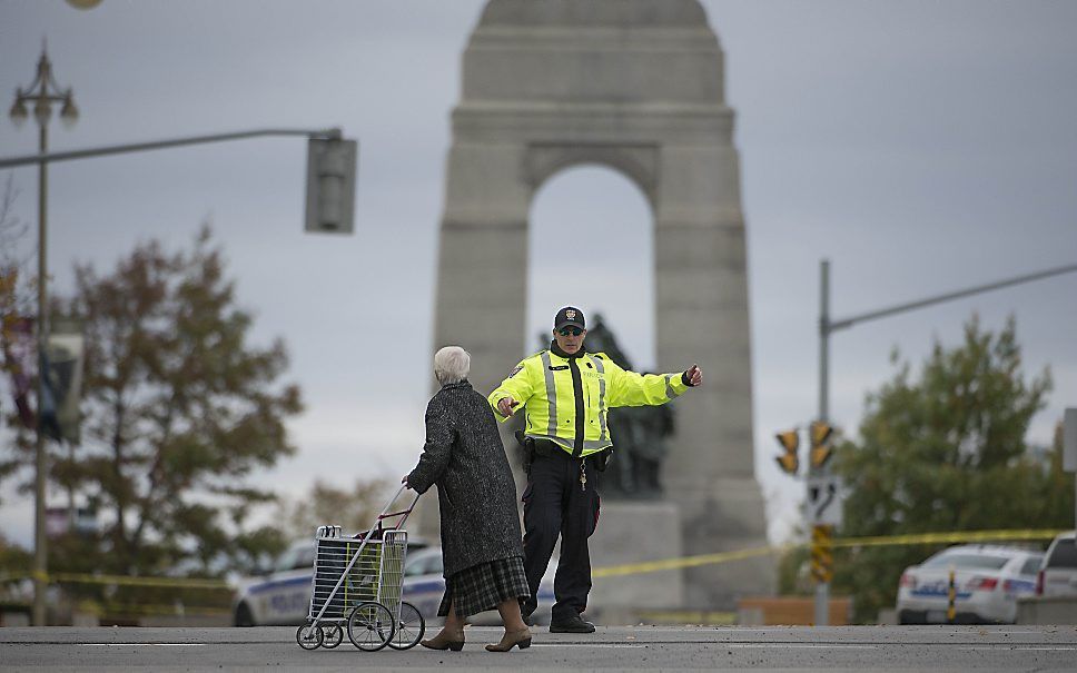 Een agent regelt het verkeer nabij het War Memorial in Ottawa. Beeld AFP