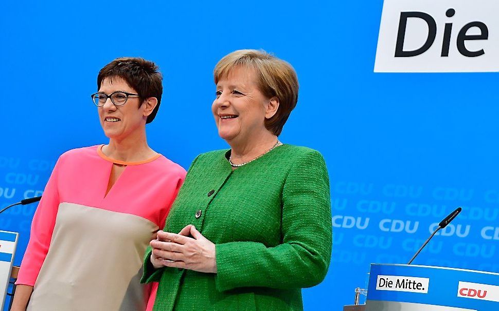 Annegret Kramp-Karrenbauer (l.) naast Angela Merkel. beeld AFP