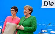 Annegret Kramp-Karrenbauer (l.) naast Angela Merkel. beeld AFP