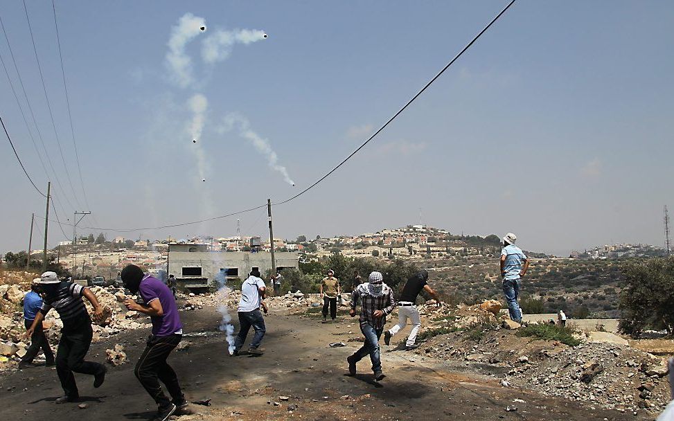 Palestijnen protesteren tegen de bouw van nieuwe nederzettingen. De Israelische politie schiet met traangas. Beeld EPA