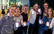 Jongeren installeerden de nieuwe app op hun smartphone tijdens de jongerenavond in Rotterdam. beeld Geloofstoerusting