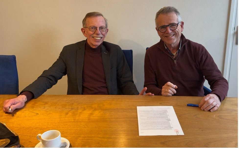 Links op de foto secretaris ds. Hero Velema, en rechts voorzitter Gert Felten, na tekening van de notariële acte. beeld Stichting Pioniers in Zuid.