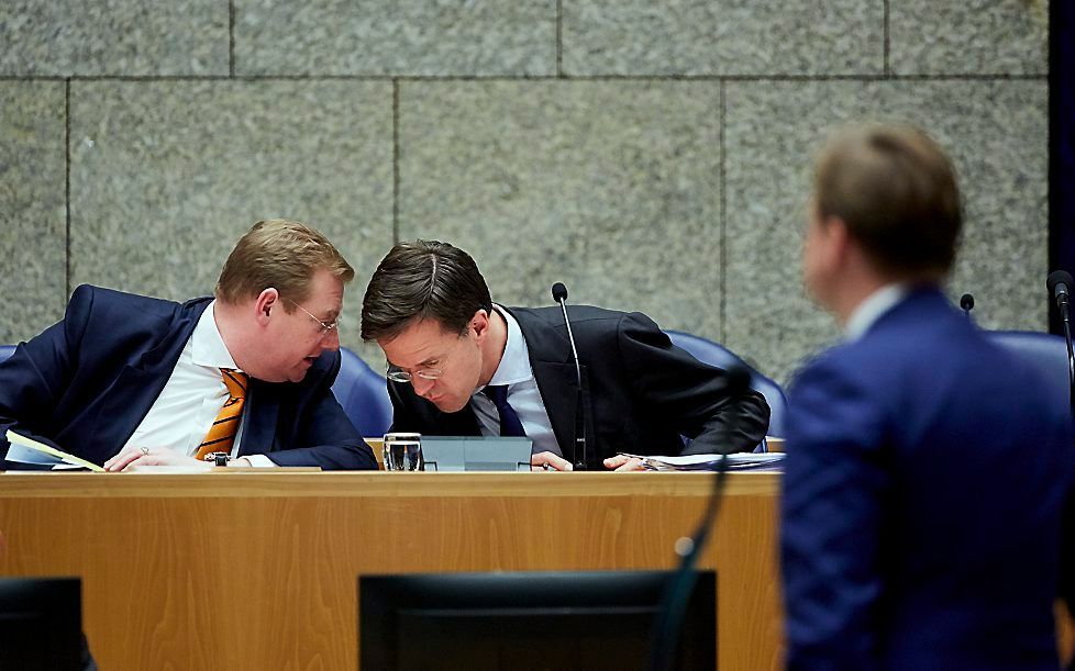 Minister Ard van der Steur en minister-president Mark Rutte overleggen tijdens het debat over het rapport van de Onderzoeksraad voor de Veiligheid naar de ramp met MH17. Beeld ANP