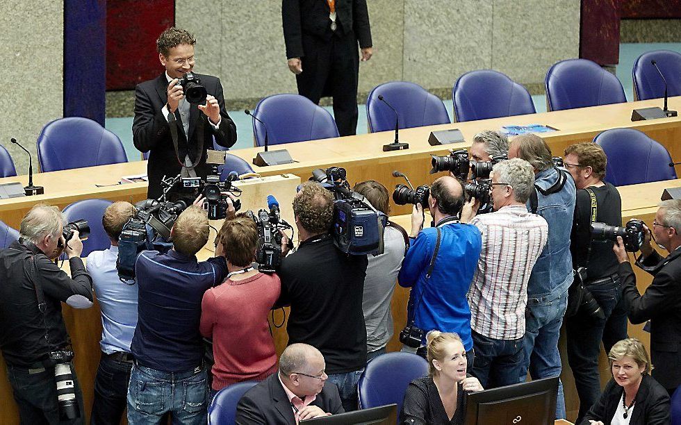 Minister Dijsselbloem van Financiën maakt in de Tweede Kamer een foto van de fotografen tijdens de presentatie van het koffertje met de Rijksbegroting en de Miljoenennota tijdens Prinsjesdag beeld ANP