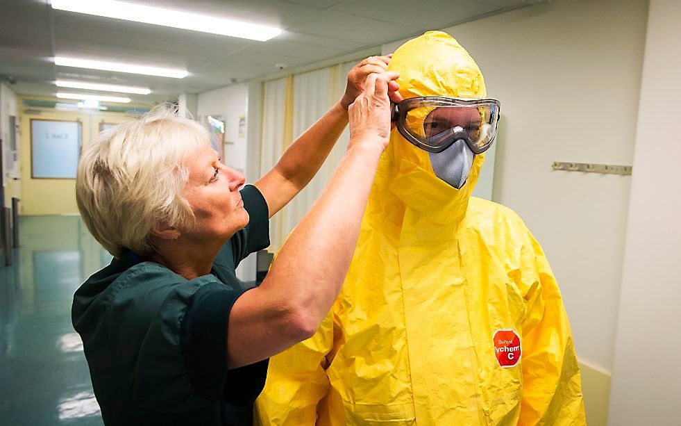 Arts pakt zich goed in voor behandeling van een mogelijk met ebola besmette patient. Beeld ANP