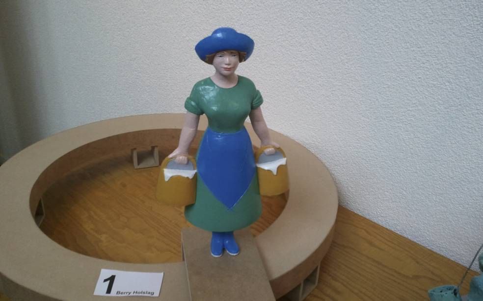 Een maquette van het Huizer melkmeisje zoals dat oorspronkelijk bedacht is door de kunstenaar Berry Holslag. Na kritiek van inwoners van Huizen krijgt het beeld –dat morgen onthuld wordt– geen blauw-groene, maar een geel-rode jurk. Foto Nel Hoogmoed