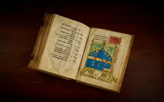 Een opengeslagen Joods gebedenboek met geschreven tekst en gekleurde afbeeldingen, afkomstig uit 1415. 
