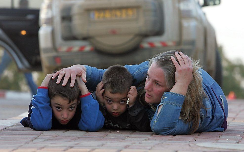 Een vrouw ligt met haar kinderen op de grond na een luchtalarm in Kfar Aza, 2009. Beeld AFP