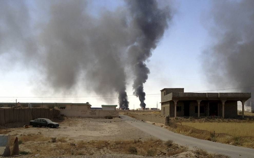 BAIJI. Rook boven olieraffinaderij Baiji, in het noorden van Irak, eind juli. IS veroverde de raffinaderij op de Iraakse troepen. Olie lijkt een belangrijke bron van inkomsten te zijn voor IS. beeld EPA