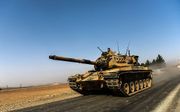 Een Turkse tank rijdt richting de grens met Syrië. Beeld AFP