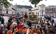 De gouden koets met daarin Koningin Beatrix, kroonprins Willem-Alexander en prinses Máxima vertrekt vanaf paleis Noordeinde richting de Ridderzaal. Foto ANP