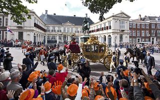 De gouden koets met daarin Koningin Beatrix, kroonprins Willem-Alexander en prinses Máxima vertrekt vanaf paleis Noordeinde richting de Ridderzaal. Foto ANP