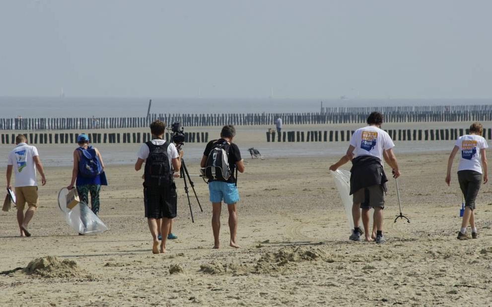 Vrijwilligers zoeken het strand af naar afval bij de aftrap van de Boskalis Beach Cleanup Tour in Cadzand-Bad. De animo om aan de grote strandschoonmaak mee te doen groeit. beeld Van Scheyen Fotografie