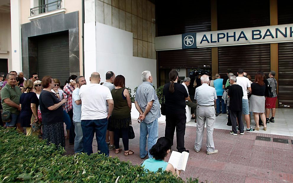 Wachten voor de pinautomaat in Athene. beeld EPA