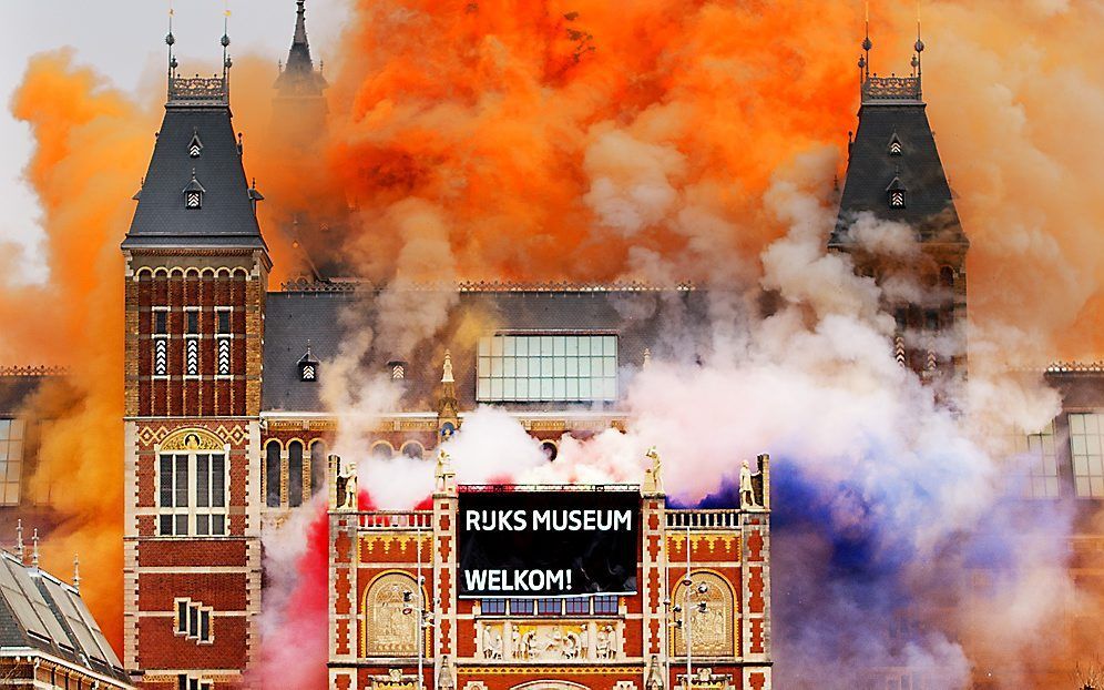 Rood-wit-blauw en oranje gekleurd vuurwerk wordt ontstoken tijdens de heropening van het Rijksmuseum. Foto ANP