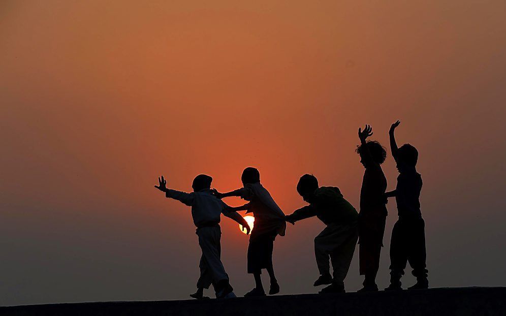 Pakistaanse kinderen spelen woensdag op het dak van een huis in Lahore. beeld AFP