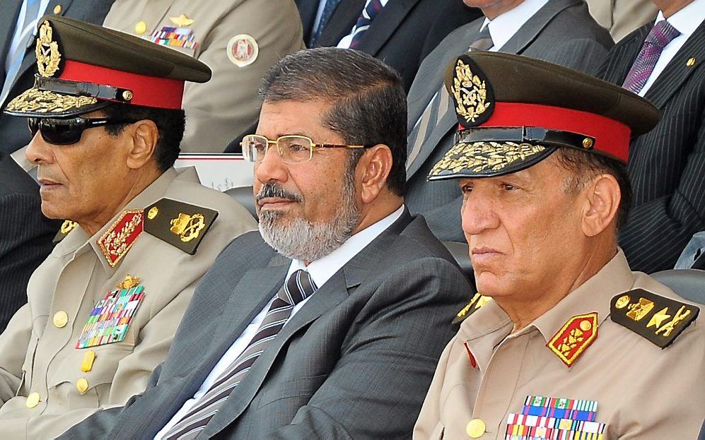 Mursi, geflankeerd door veldmaarschalk Tantawi (l.) en legerleider Sami Anan, tijdens een militaire parade maandag. Foto EPA