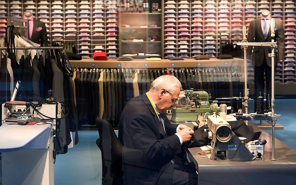 Een kleermaker aan het werk in de winkel van Suitsupply op Schiphol. beeld ANP