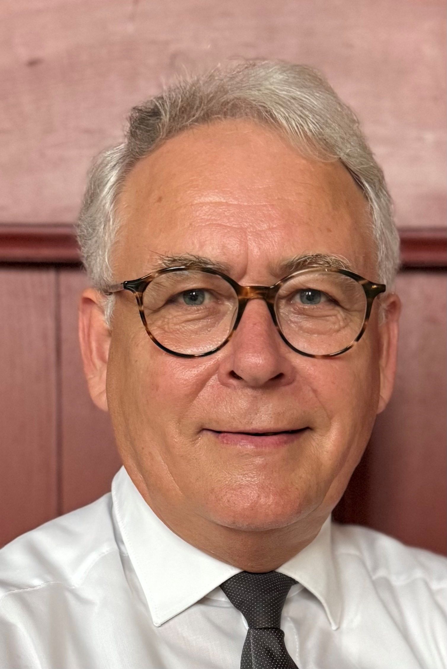 Een man met grijs haar en een bril.