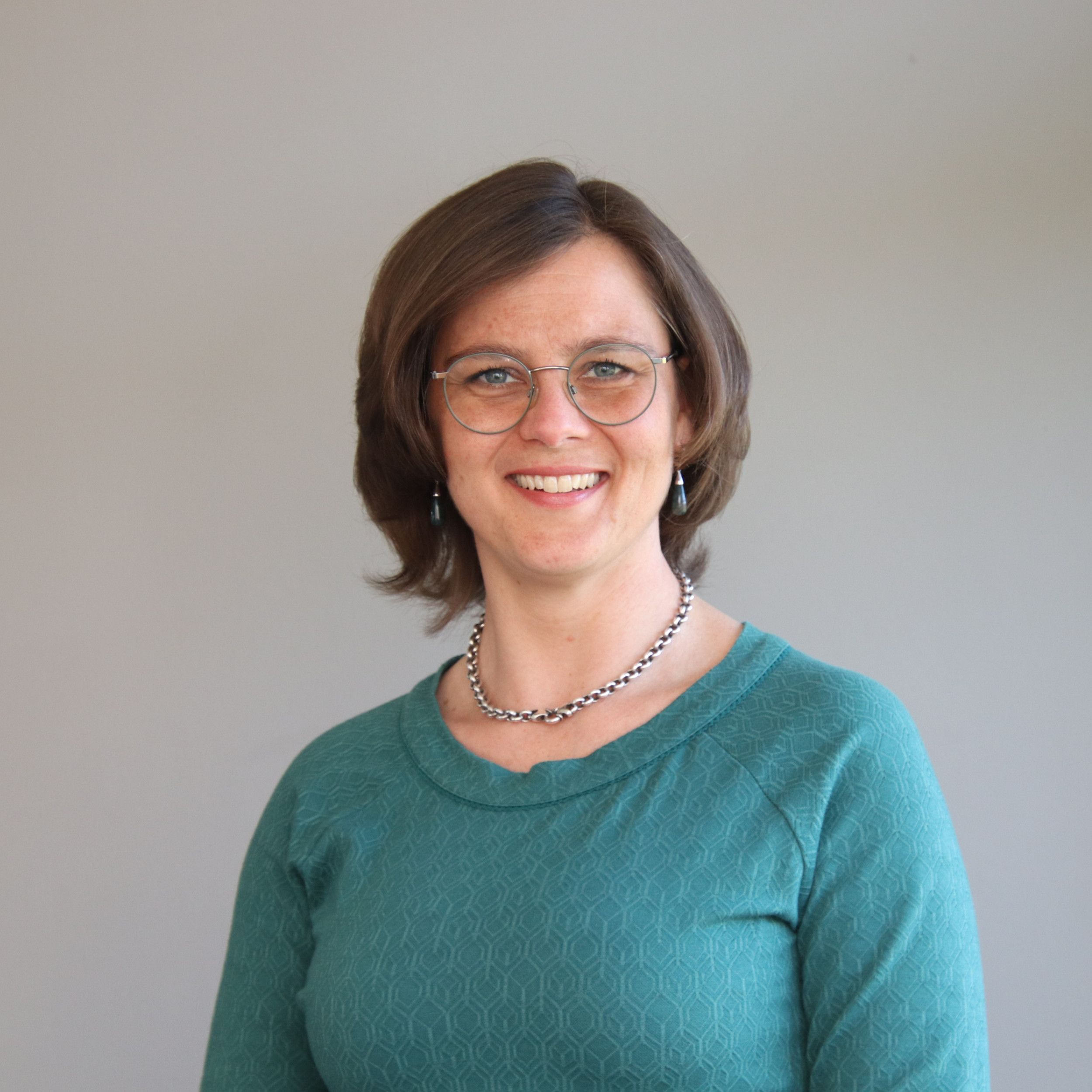 Portret van vrouw met bril en halflang bruin haar.