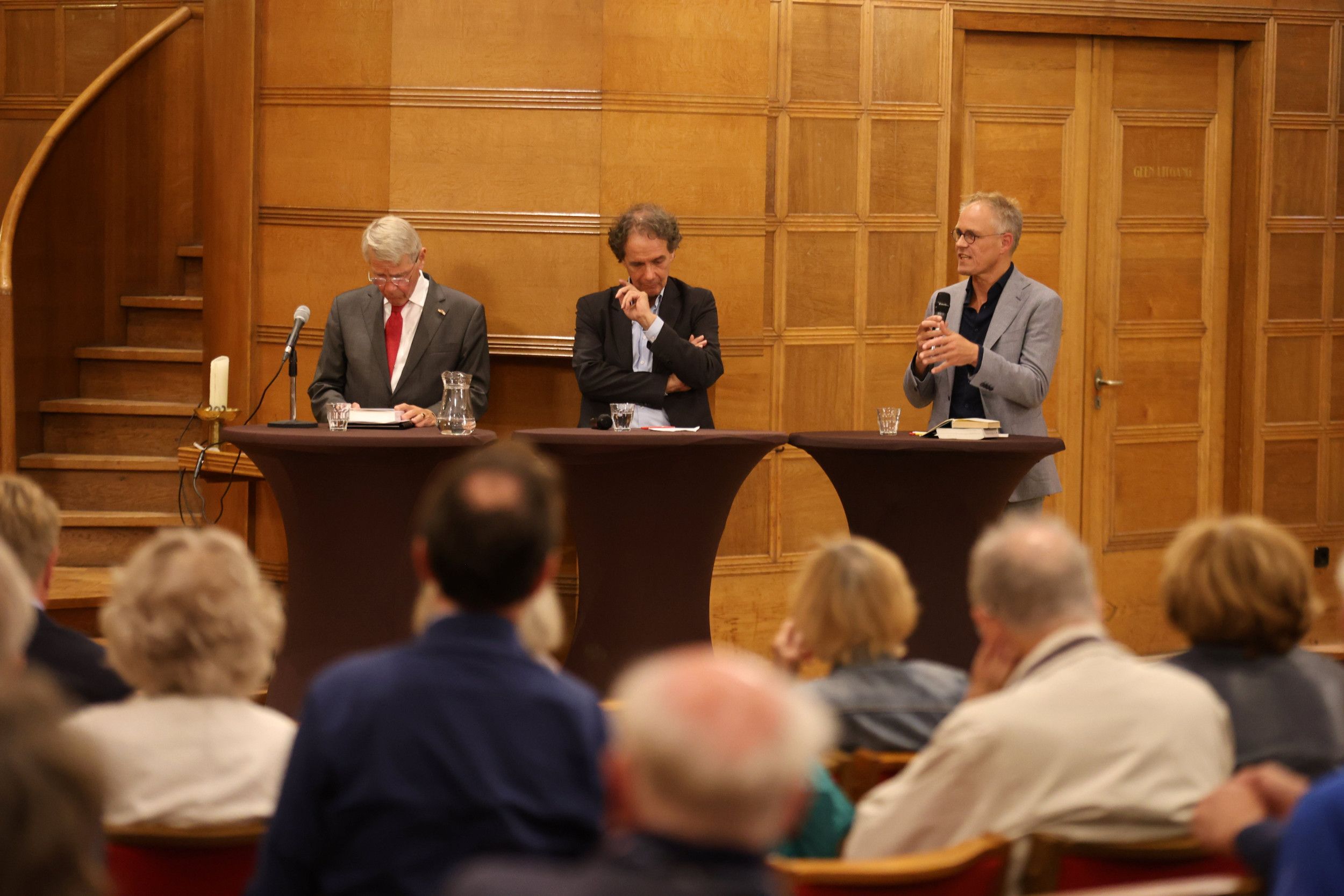 Drie mannen achter bartafeltjes.