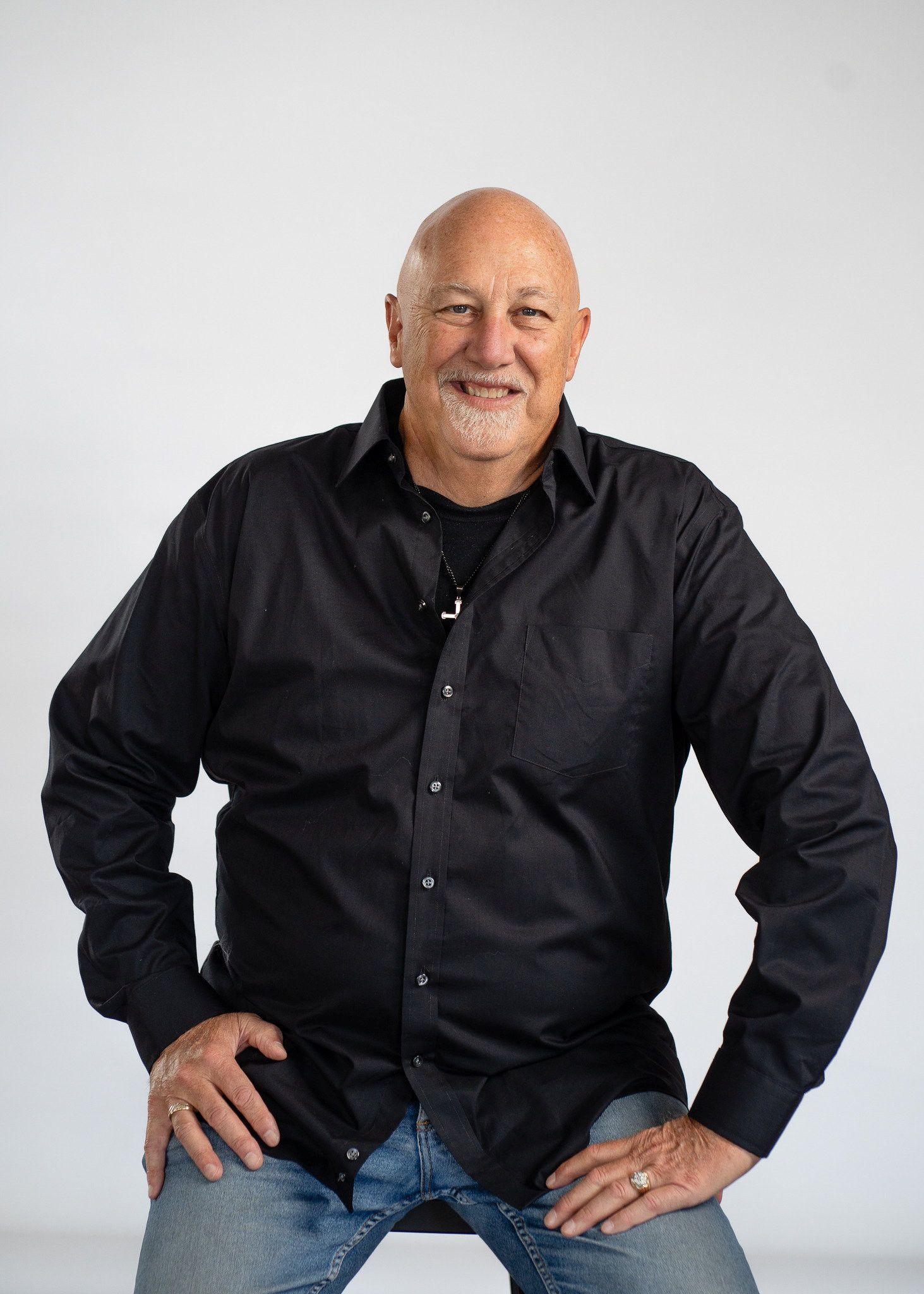 Kale man met een donker overhemd een spijkerbroek.