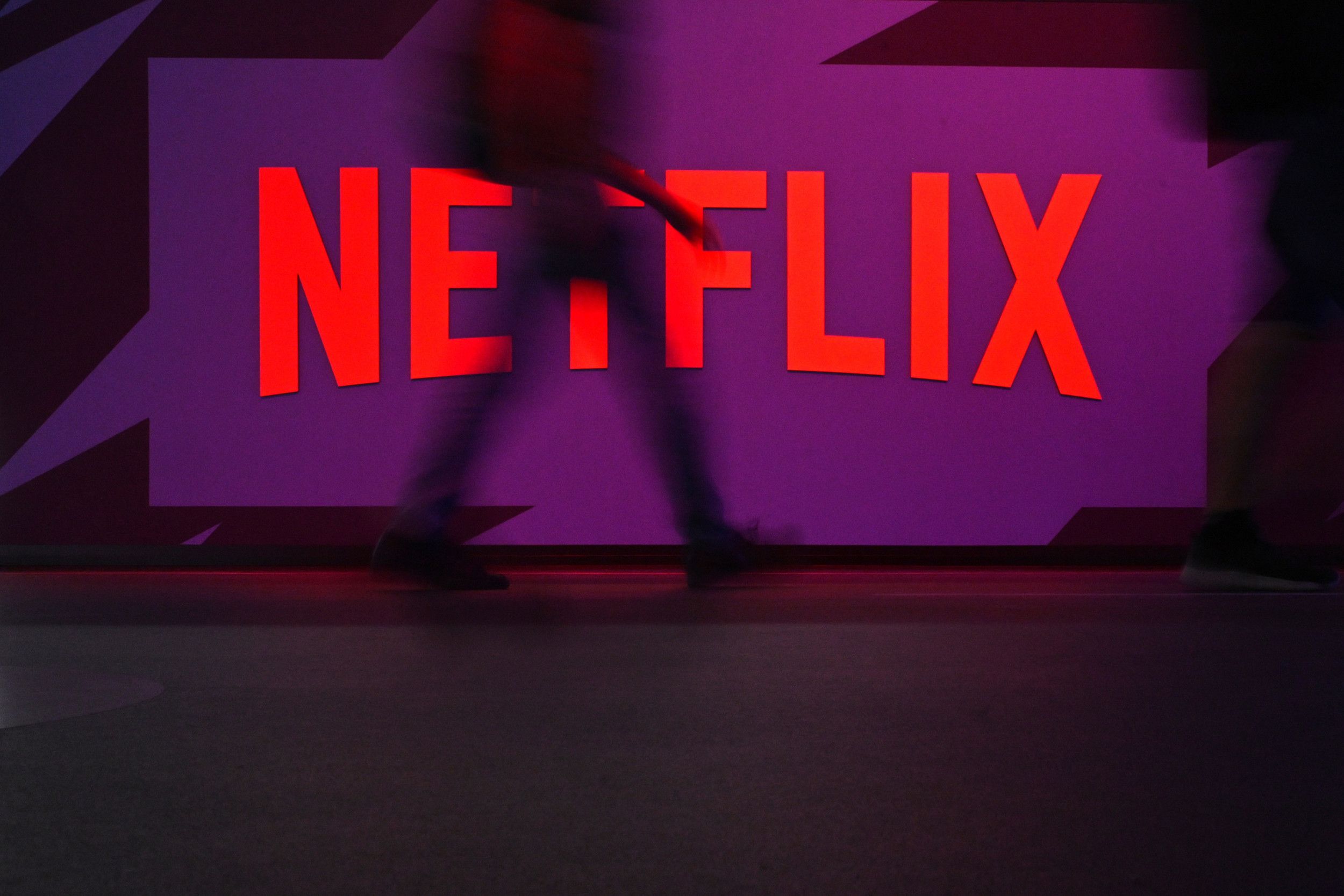 Scherm met daarop het woord Netflix. Er loopt iemand langs.