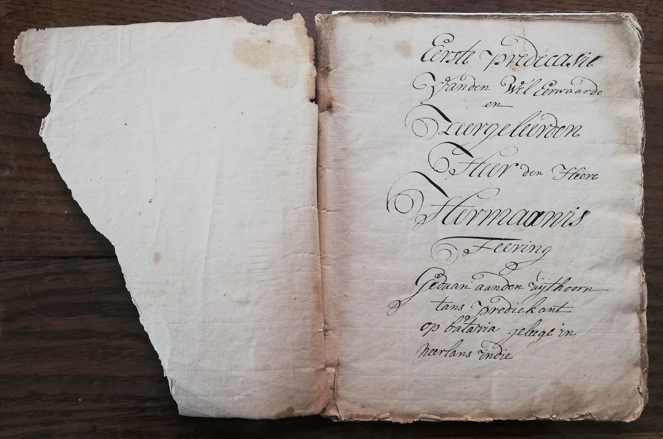 Oud papierfragment met daarop krullerige, zwarte letters.